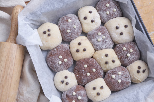Close up of bread rolls in baking sheet by rolling pin on table