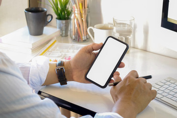 Young businessman and his cellphone in office