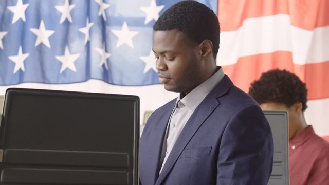 Young man  voting in a voting booth