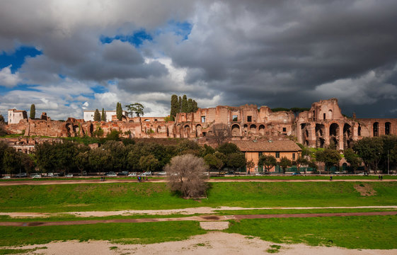 Panoramic view of the Ancient Rome Imperial Palace ruins on Palatine Hill with stormy clouds from Circuss Maximus, in the historic center of Rome
