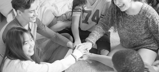 Group of teenagers in a bedroom putting their hands together community and temwork concept