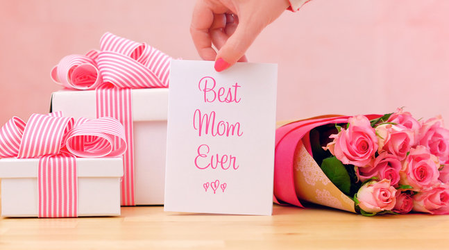 Happy Mother's Day gift, pink roses and Best Mom Ever greeting card on table.