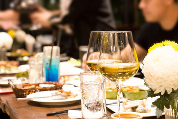 Group of friends raising a toast with glasses of white wine