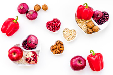 Diet for healthy heart. Food with antioxidants. Vegetables, fruits, nuts in heart shaped bowl on white background top view