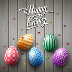 Happy Easter egg with confetti on wooden gray background