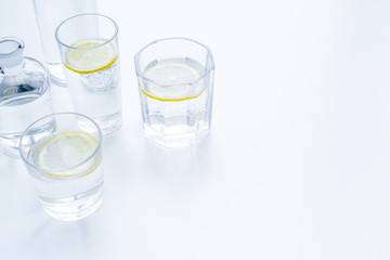 Refreshing drink. Water with lemon on white background top view copy space
