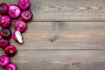 Naklejka premium Red onion for salads on dark wooden background top view copy space