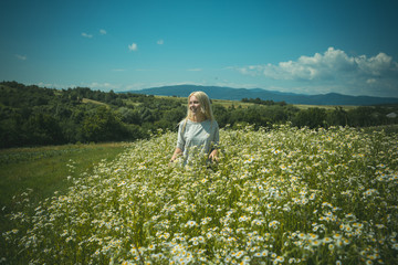 The beautiful woman in field of chamomiles