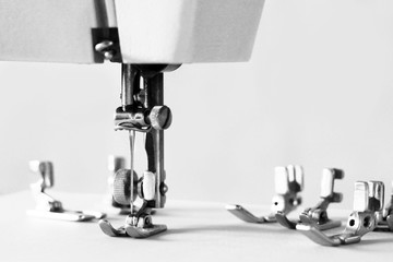 Group of sewing machine accessories. Various presser feet are used for different tasks and stem types.