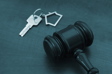 Judge gavel and keys with kechain on wooden table