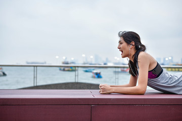 Sports concept. Beautiful girl is exercising on the beach with warm up. Beautiful girl is happy to exercise.