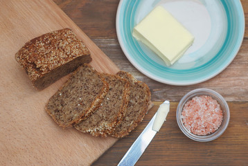 Whole Grain Bread with Seeds. Breakfast. fitness Diet Bread Sliced with Butter. Wooden board.
