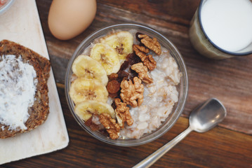 Breakfast with Granola Bowl, Muesli with Oats, Nuts and Dried Fruit, Milk, on Wooden table. Bannana, nuts, fruits. Healthy Breakfast. Diet.