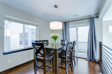 Light filled dining room with dark wood table set.