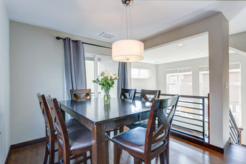 Light filled dining room with dark wood table set.