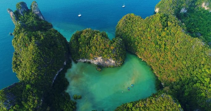 AERIAL. Group of amazing tropical islands and beautiful blue lagoon at sunset. Drone footage of national park in Thailand.