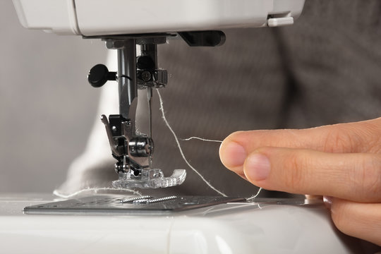 hand insert a thread into the needle of sewing machine