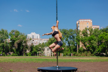 Fit attractive girl dancing near portable pole at summer day © Smile