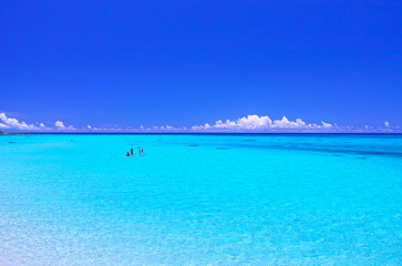 真夏の宮古島・下地空港沿いに広がる綺麗な海でマリンスポーツを楽しむ人々
