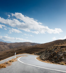 Winding road and landscape against cloudy sky