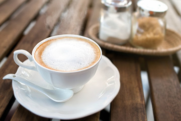 Hot cappuccino one cup on wooden table