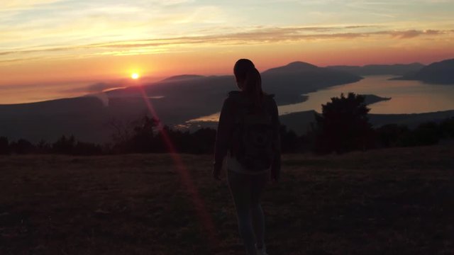 Woman successful hiking climbing silhouette in mountains, motivation and inspiration landscape on island and ocean. Hiker with arms up outstretched on mountain top looking at beautiful view.