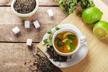 cup of black tea with mint leaves on a wooden table