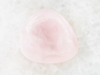 tumbled pink Quartz gem stone on white marble