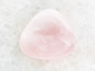 polished pink Quartz gem stone on white marble