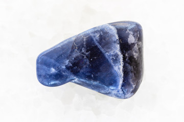 tumbled Dumortierite gemstone on white marble