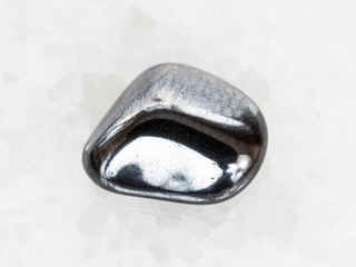 tumbled hematite gem on white marble