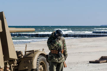 WEHRMACHT - German soldier and anti-aircraft gun on the sea beach