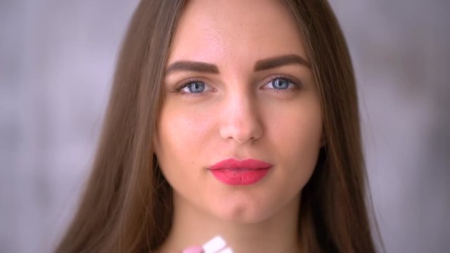 close-up, female mouth. the woman puts the chewing gum in her mouth and chews it. slow-motion