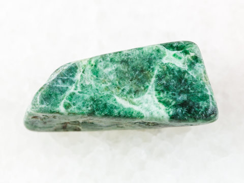 polished green jadeite stone on white