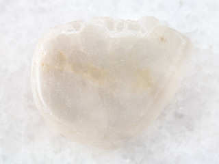 tumbled Ulexite gemstone on white marble