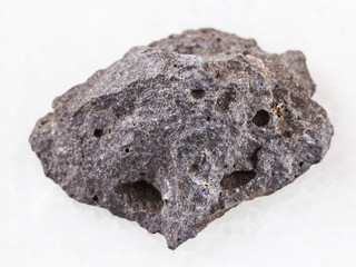 pebble of gray basalt stone on white marble