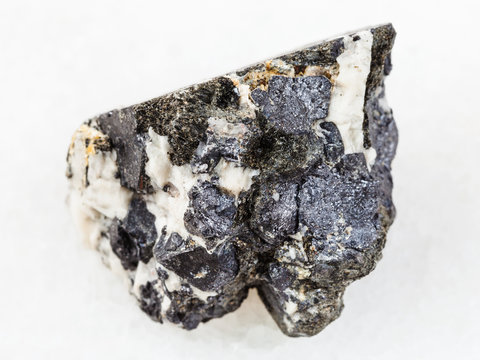 raw Knopite stone on white marble