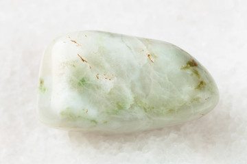 polished vesuvianite gemstone on white marble