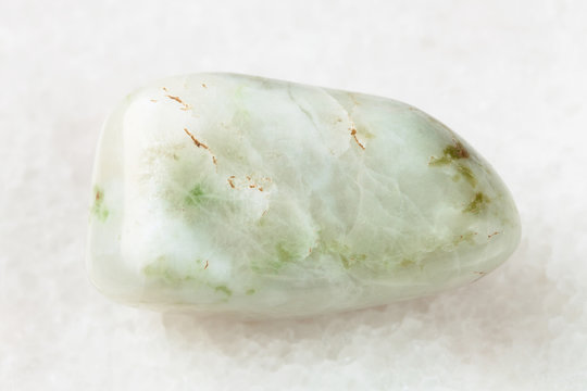 polished vesuvianite gemstone on white marble