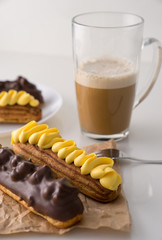 Traditional French eclairs with coffee. Good Breakfast. Closeup. On white background