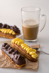 Traditional French eclairs with coffee. Good Breakfast. Closeup. On white background