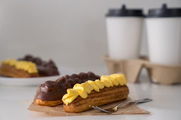 Traditional French eclairs with coffee. Good Breakfast. Closeup. On white background