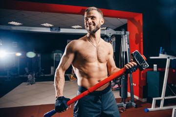 Fototapeta na wymiar Sports training for endurance, Man stands with heavy hammer. Concept workout