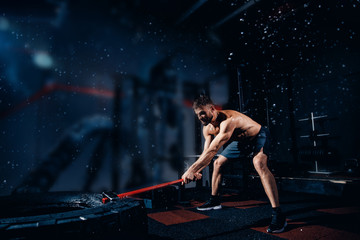 Sports training for endurance, man hits hammer with heavy hammer, sledge hammer. Concept workout