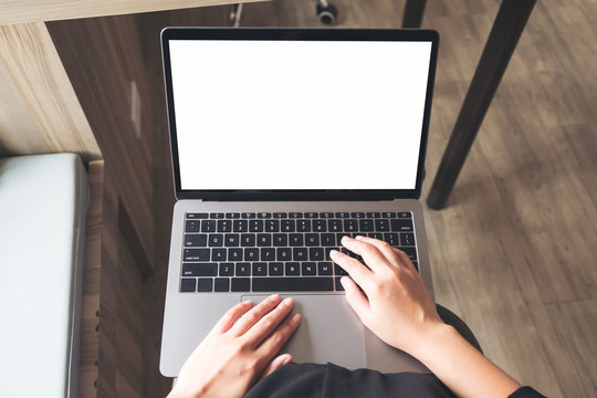 Top view mockup image of business woman using and typing on laptop with blank white desktop screen while sitting in office