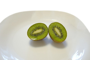 cut, juicy KIWI on a light dish. white background