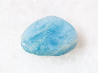 tumbled aquamarine (blue beryl) gem stone on white