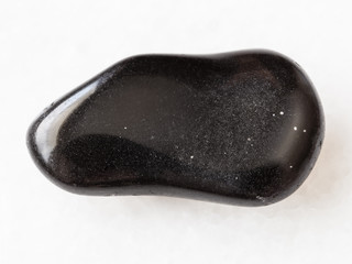 polished black obsidian gemstone on white