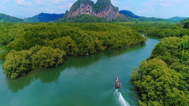 AERIAL. Top view of traditional thai boat at Krabi, Thailand. Mountains on background