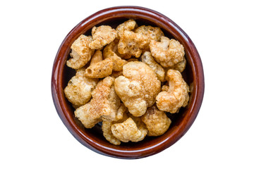 Pork rinds served in clay pot. Appetizer that consists of frying the skin and subcutaneous fat of the pig. White isolated.